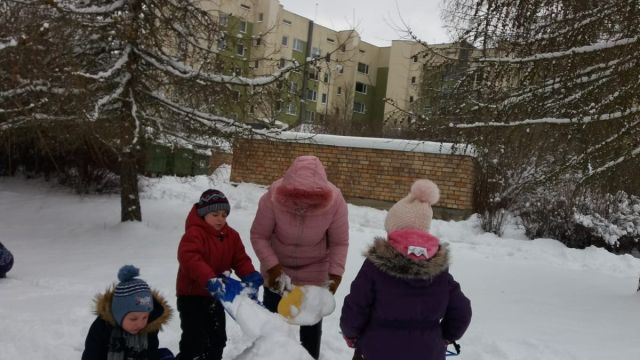 Bērni ceļ sniega skulptūras