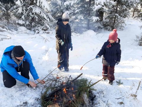 bērni cep desiņas ugunskurā