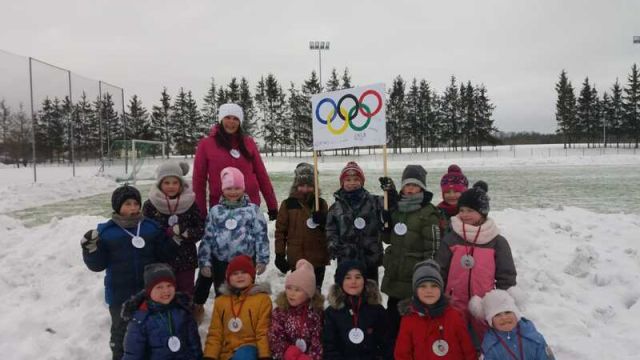 pirmsskolas bērnu grupa ar olimpisko apļu simbolu