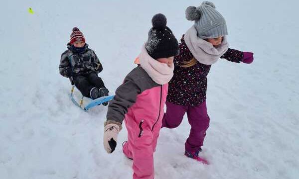 bērni velk viens otru ar ragavām