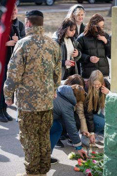 skolēni noliek ziedus