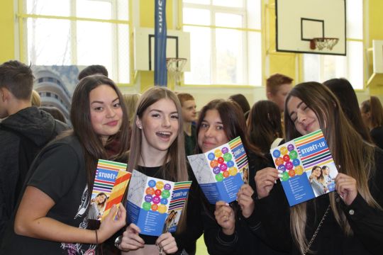 meitenes ar LU informatīvajiem bukletiem