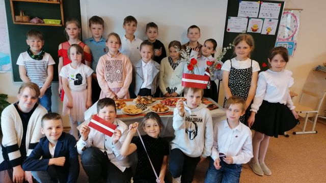 Klase pie balti klāta galda par godu LR Neatkarības atjaunošas svētkiem.