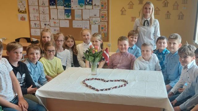 Klase pie balti klāta galda par godu LR Neatkarības atjaunošas svētkiem.